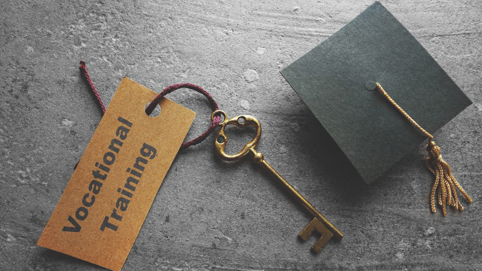 Graduate cap sitting next to a key that is labeled vocational training. 